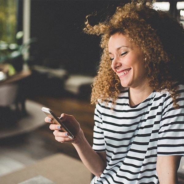 woman smiling looking at her phone